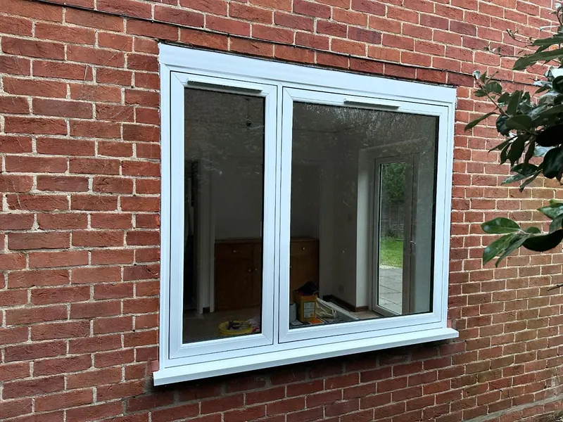 Double glazed white uPVC casement window in a red brick wall