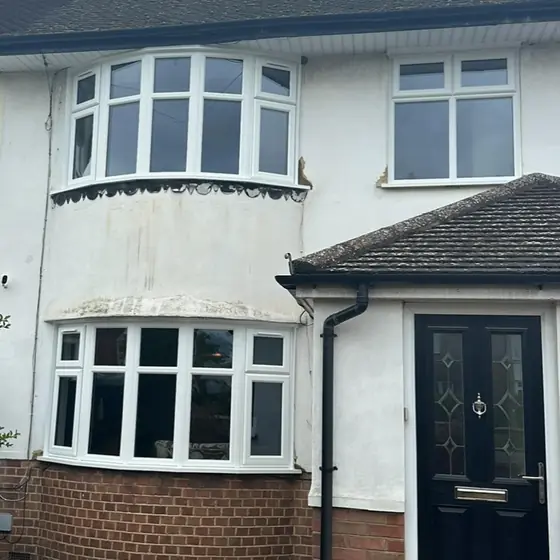 1930s-style semi-detached house with white bay windows and a black composite door