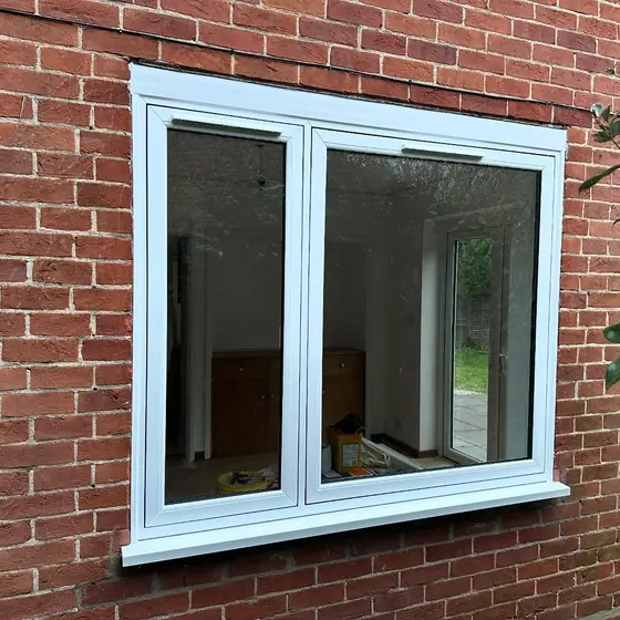 White double glazed casement window in a red brick wall