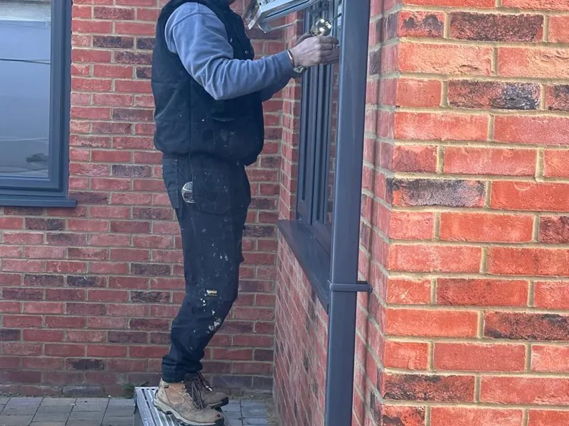 L.D.M Installation fitter repairing a window frame on a brick house